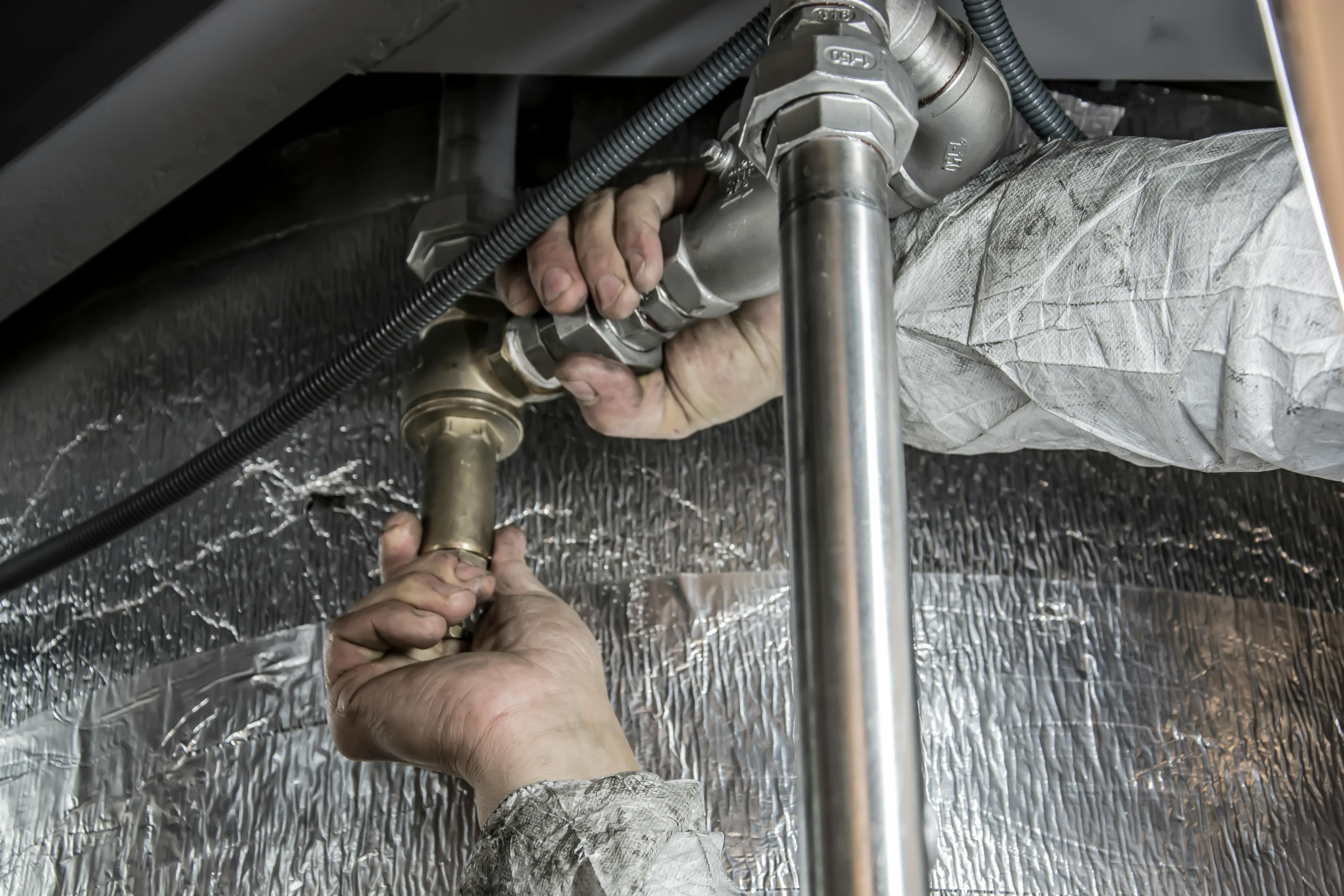 Plumber working under a sink